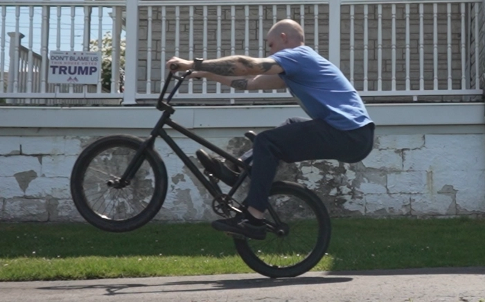 Billy Kennedy showing how the legs are extended while performing a manual on a BMX Bike.